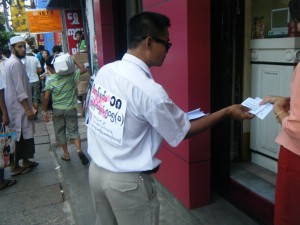 Protester Hands out Leaflet about Article 18 - Photo © MDCF