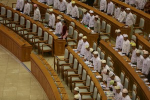 Myanmar pro-democracy leader Aung San Suu Kyi (top centre-L) and members of parliament stand as the Parliament Speaker (unseen) enters during the Union Parliament regular session in Naypyitaw March 26, 2015. REUTERS/Soe Zeya Tun - RTR4UWIT