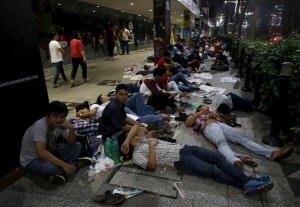 Myanmar nationals camp outside the Myanmar embassy as they wait for polling stations to open for advance voting in Singapore